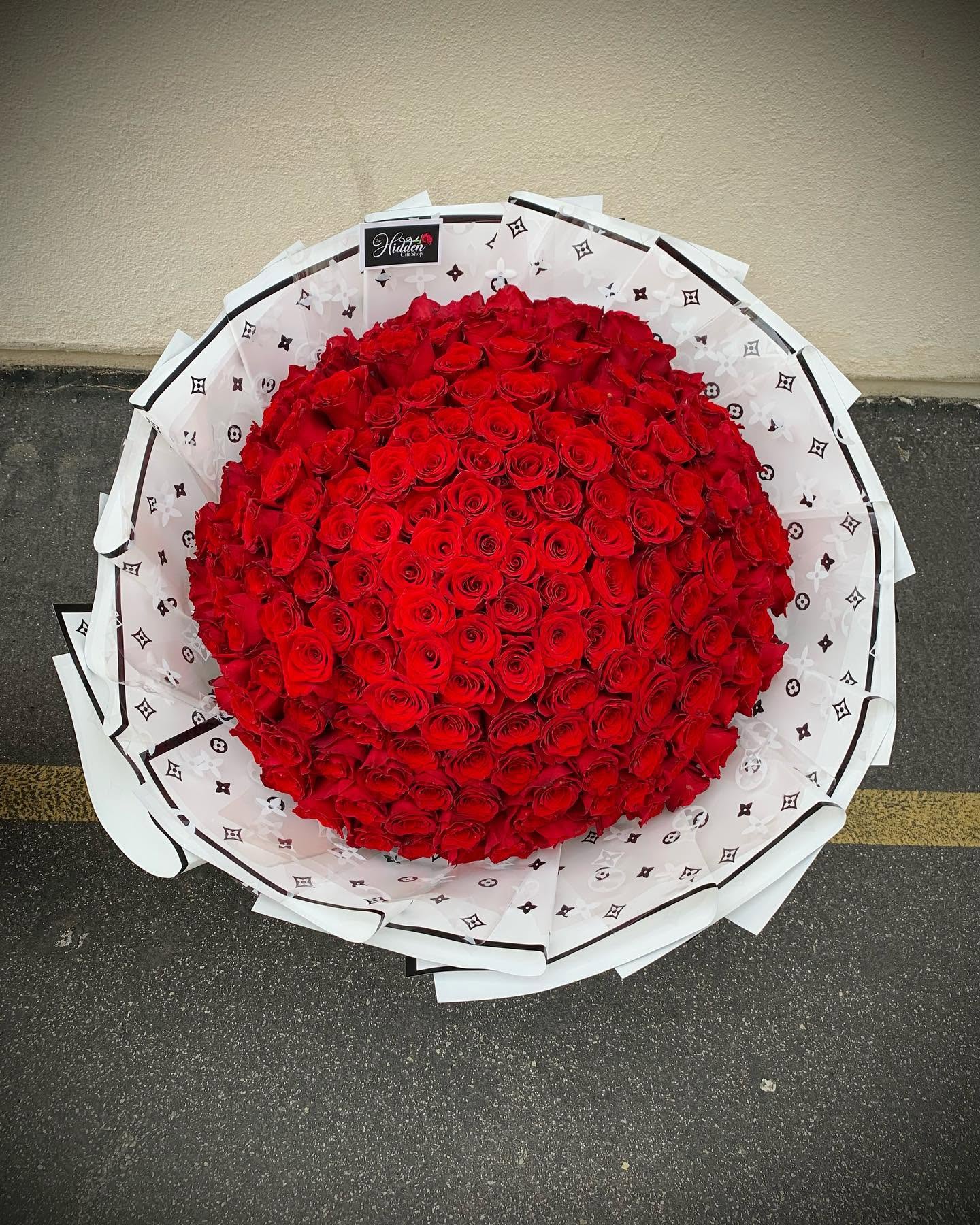 Large luxury bouquet of red roses wrapped in elegant white floral paper from The Hidden Gift Store