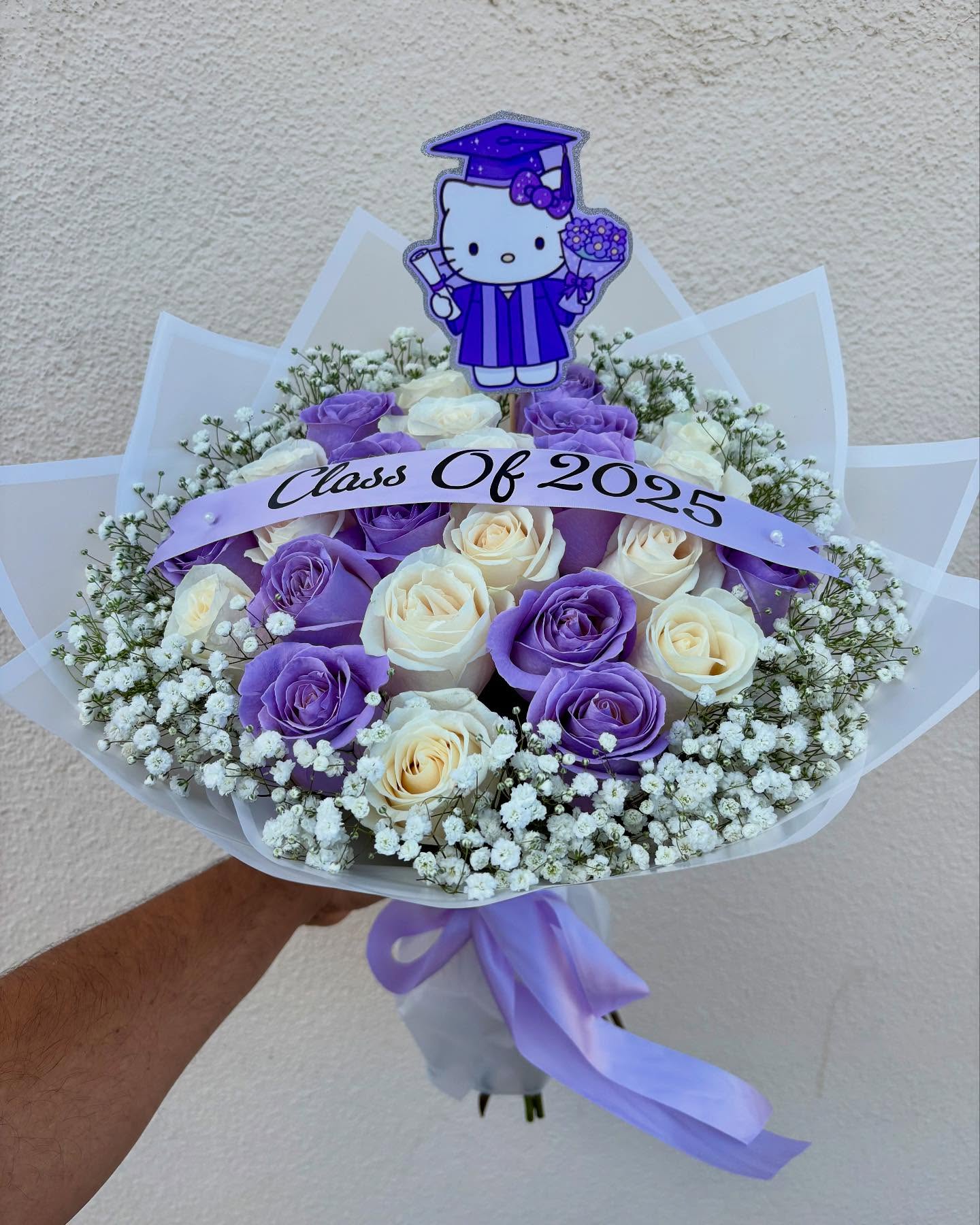 Hello Kitty graduation bouquet with purple and white roses, baby’s breath, and Class of 2025 ribbon