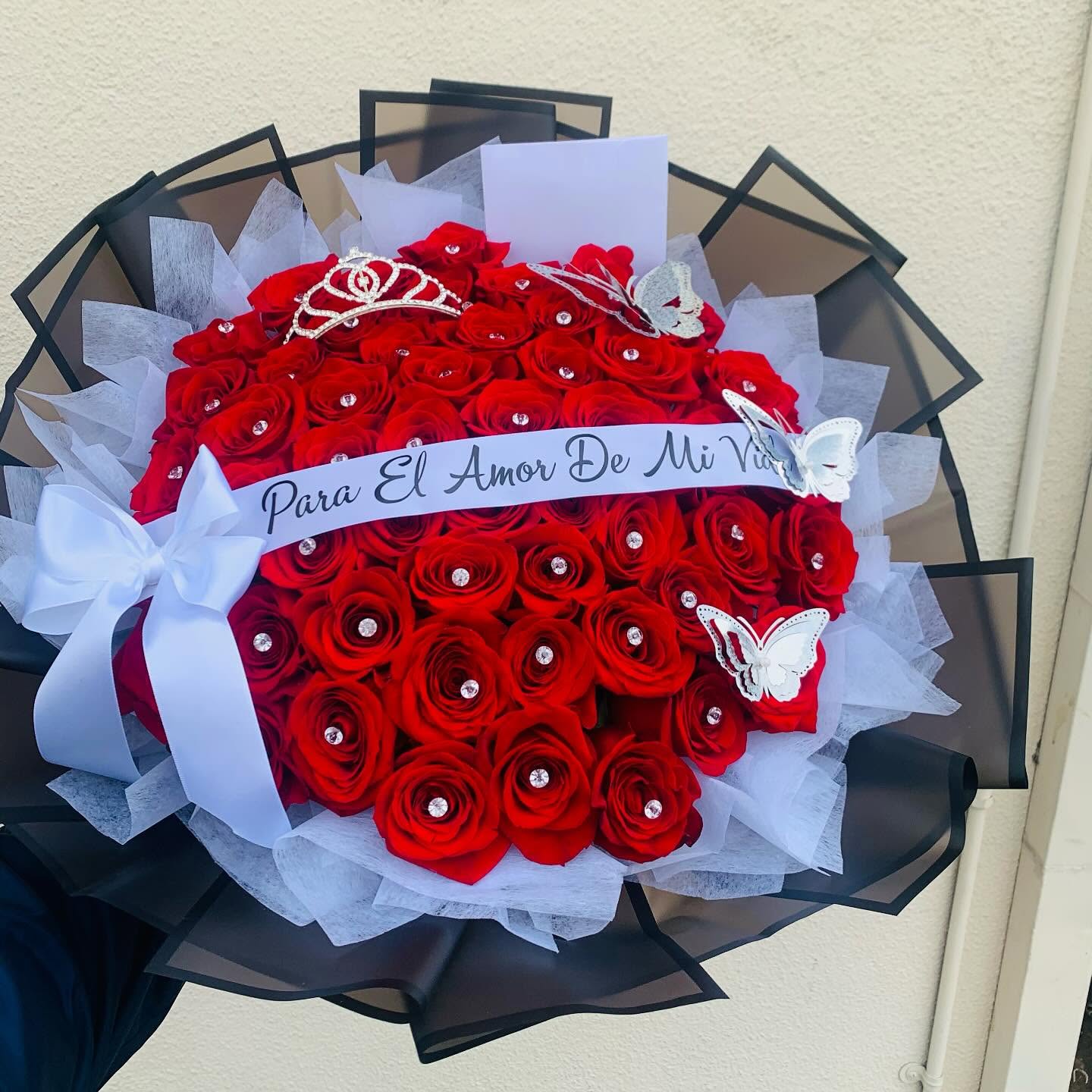 Luxury red rose bouquet with rhinestone accents, silver tiara, butterflies, and romantic Spanish ribbon