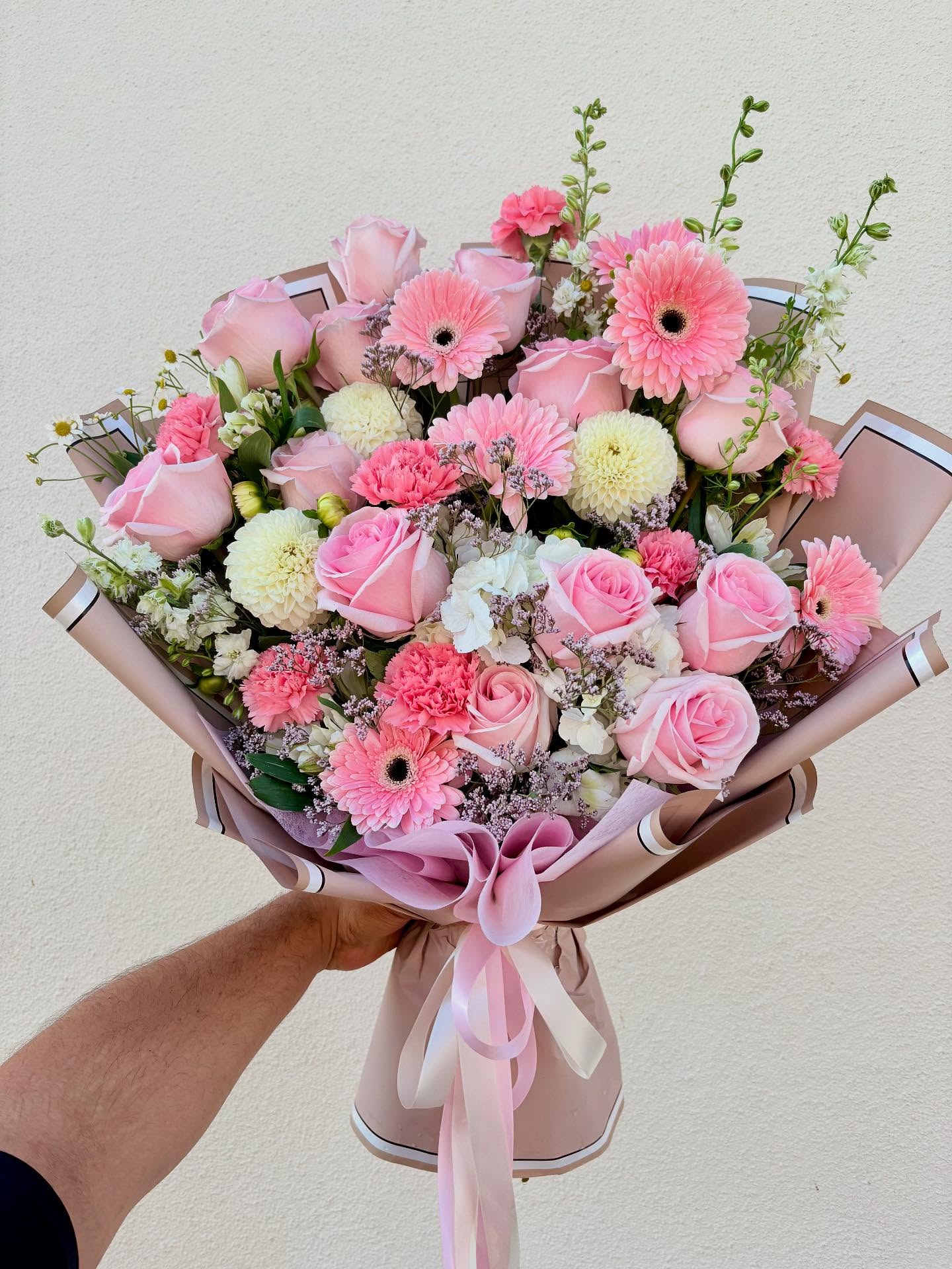 Elegant pink flower bouquet with roses, gerbera daisies, carnations, hydrangeas, and white chrysanthemums