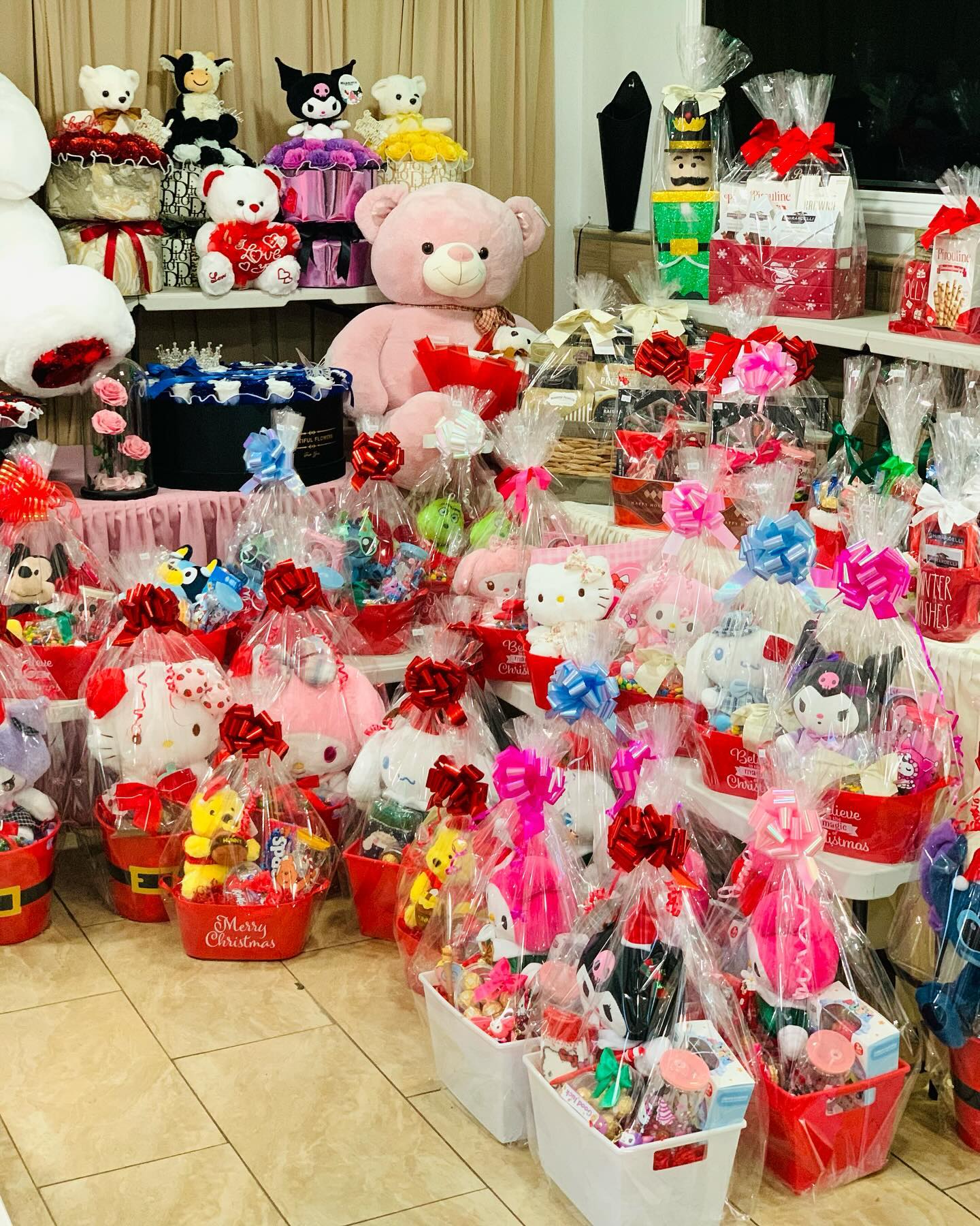 Holiday gift baskets featuring plush toys, candy, treats, festive bows, and Christmas-themed gift sets.