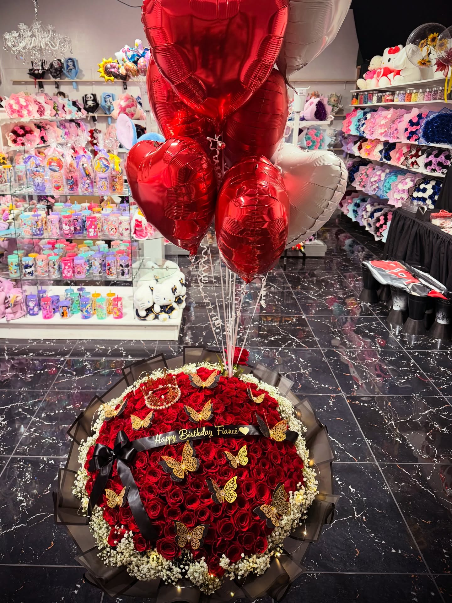 Luxury birthday bouquet featuring red roses, baby’s breath, gold butterfly accents, heart-shaped balloons, and a personalized “Happy Birthday Fiancé” ribbon.