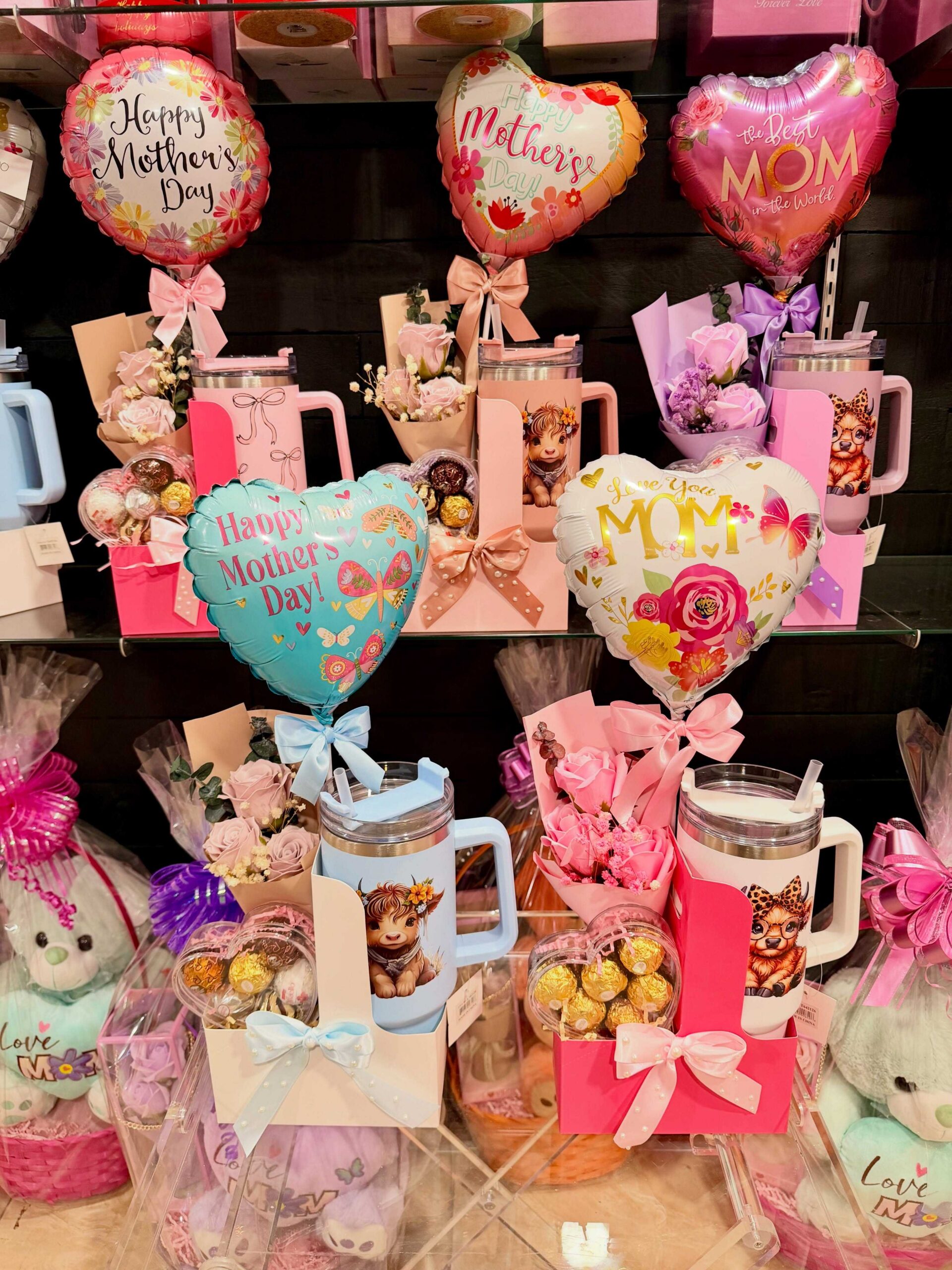 Mother’s Day gift sets with floral bouquets, balloons, tumblers, chocolates, and decorative bows