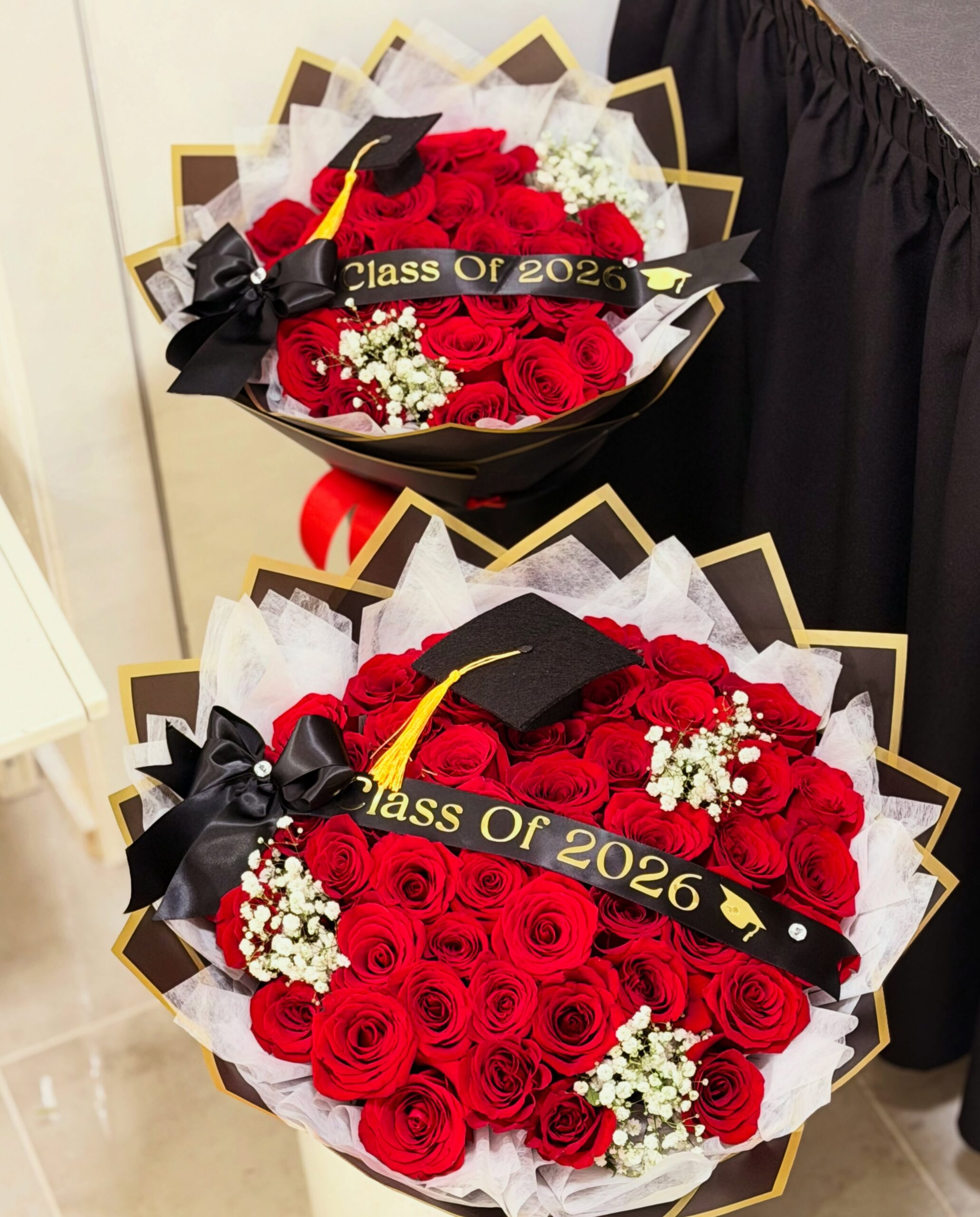 Graduation flower bouquets with red roses, black and gold wrapping, and Class of 2026 decorations